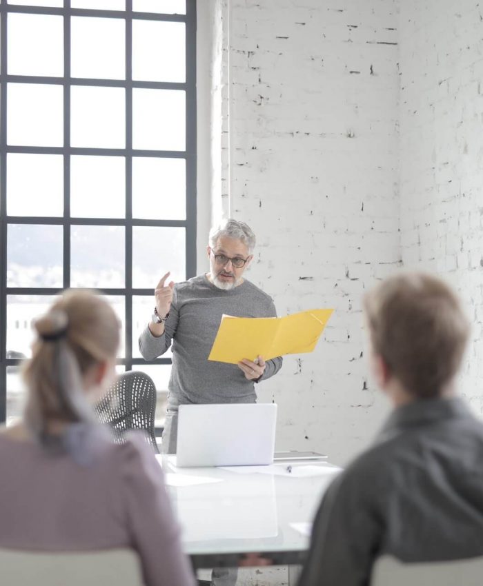 male-boss-speaking-to-multiracial-colleagues-at-conference.jpg